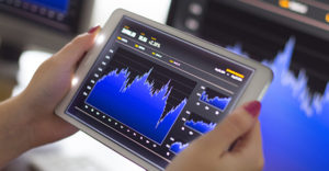 Business woman holding a digital tablet pc analyzing stock market graph. Selective focus.